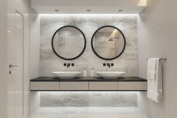 EE4F7232-F3F1-4AD4-9150-D698BD111AB4 Modern kitchen with white cabinets, marble island, four barstools, pendant lights, and wood accents.