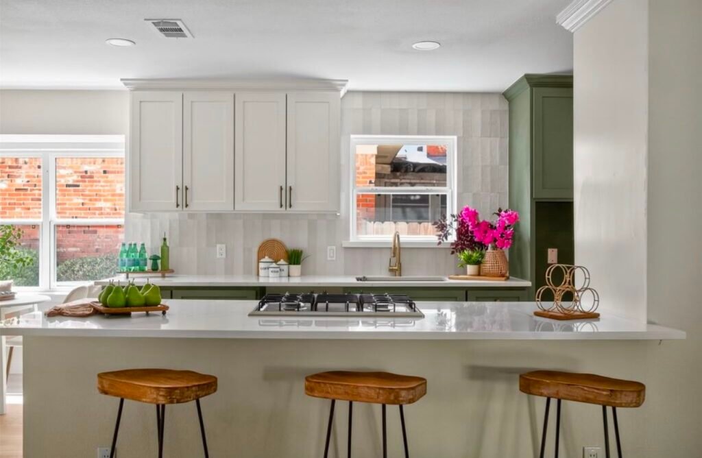 Modern kitchen with white cabinets, a large island, pendant lights, and wooden accents.