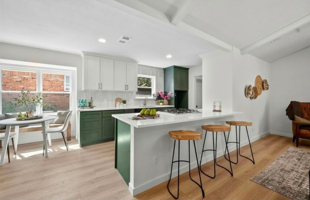 Modern kitchen with white cabinets, a large island, pendant lights, and wooden accents.