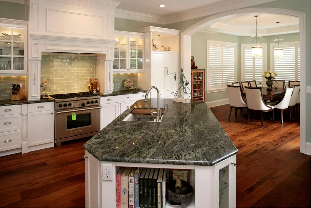 Modern kitchen with white cabinets, a large island, pendant lights, and wooden accents.