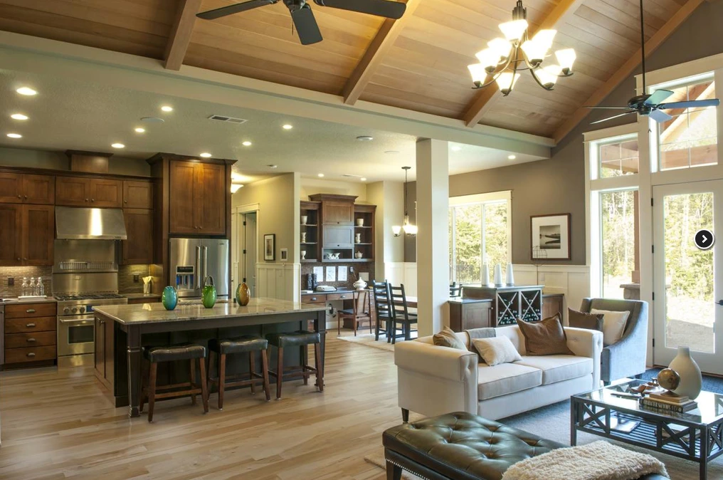Modern kitchen with white cabinets, a large island, pendant lights, and wooden accents.