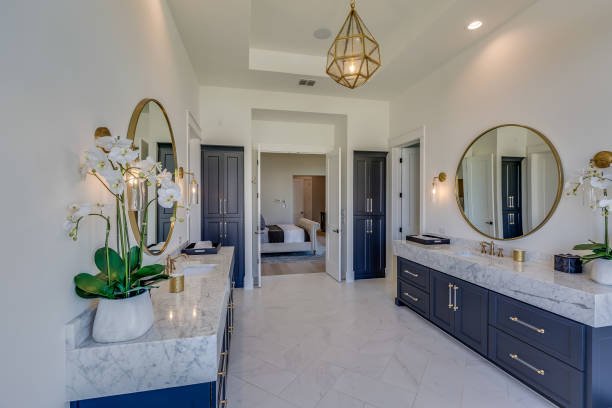 Modern kitchen with white cabinets, a large island, pendant lights, and wooden accents.