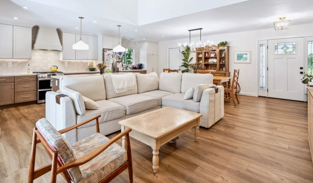Modern kitchen with white cabinets, a large island, pendant lights, and wooden accents.