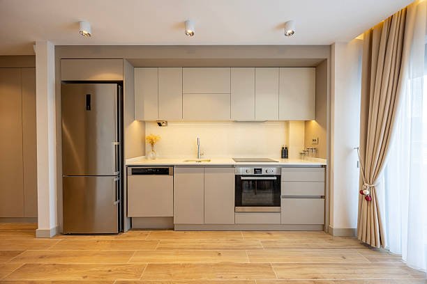 Modern kitchen with white cabinets, a large island, pendant lights, and wooden accents.
