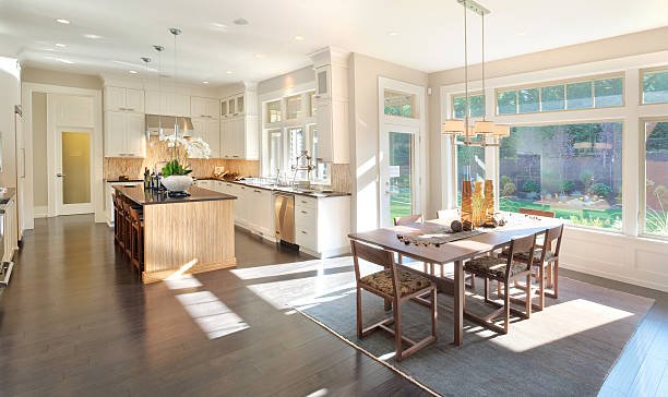 Modern kitchen with white cabinets, a large island, pendant lights, and wooden accents.