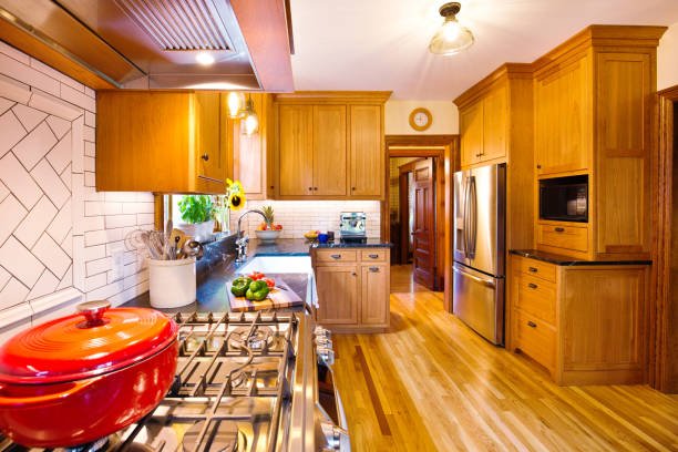Modern kitchen with white cabinets, a large island, pendant lights, and wooden accents.