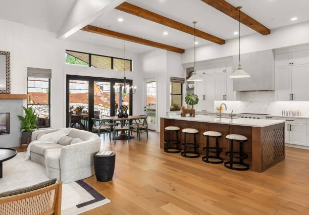 Modern kitchen with white cabinets, a large island, pendant lights, and wooden accents.