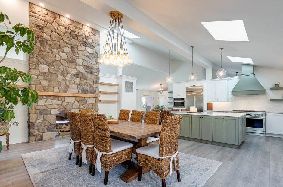 Modern kitchen with white cabinets, a large island, pendant lights, and wooden accents.