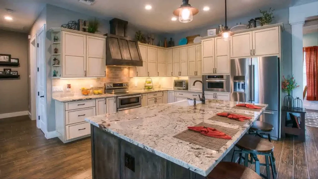 Modern kitchen with white cabinets, a large island, pendant lights, and wooden accents.
