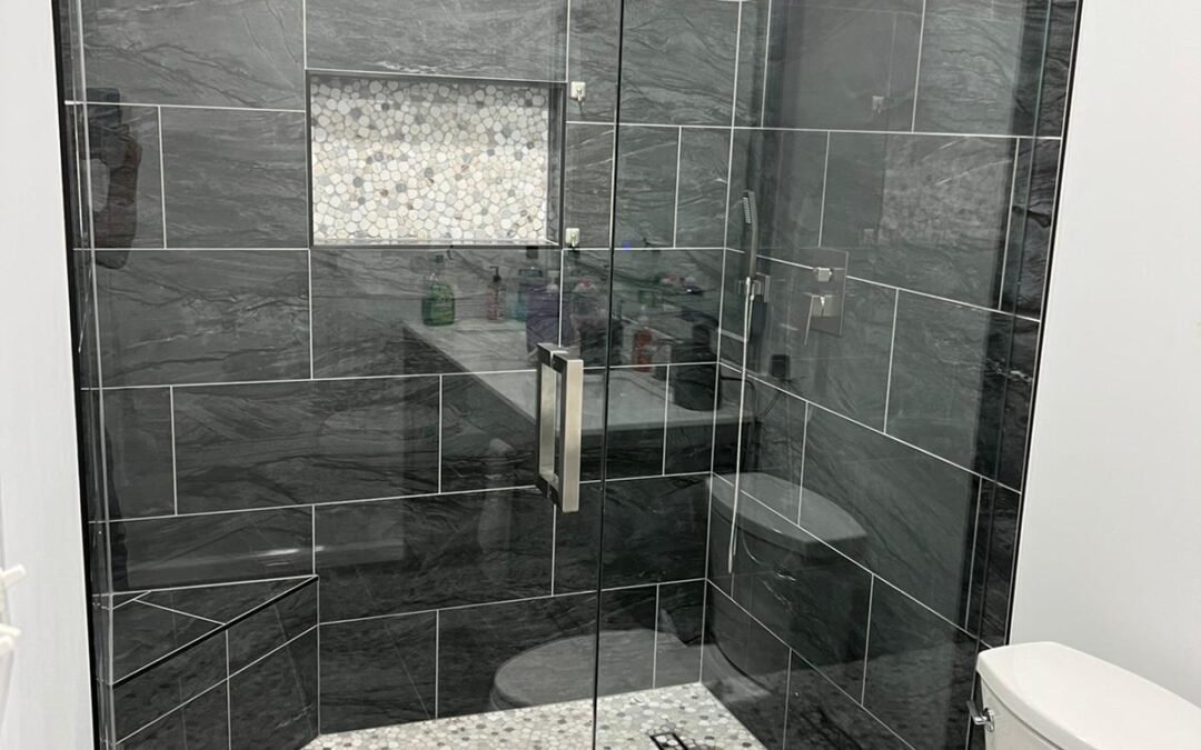 Walk-In Shower Remodel with Dark Tile, Pebble Floor, and Built-In Bench