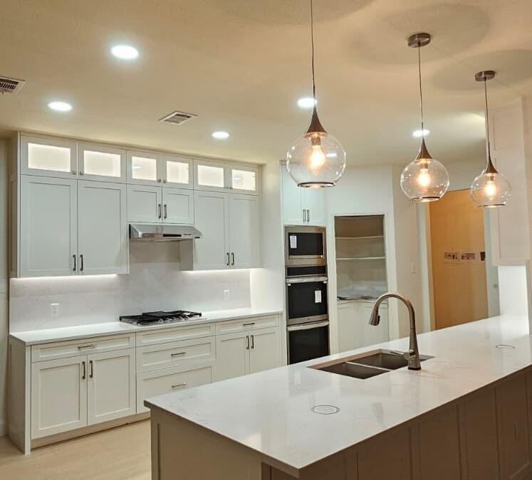 White Shaker Kitchen Remodel with Wall Ovens and Lit Glass Cabinets
