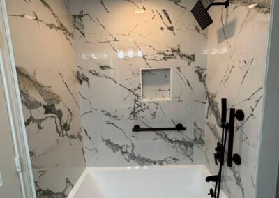 Bathroom Remodel with Marble-Look Tile, Matte Black Fixtures, and Sliding Glass Shower