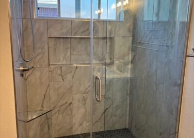 Walk-In Shower Remodel with Marble-Look Tile and Sliding Glass Door